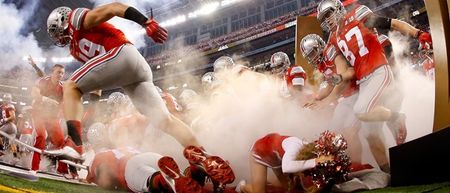 PICS: Ohio State cheerleader somehow managed to avoid being trampled by players